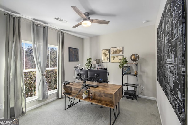 carpeted office space featuring ceiling fan