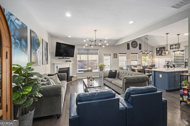 living room featuring a notable chandelier, dark hardwood / wood-style flooring, and vaulted ceiling