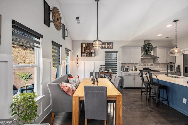 dining room featuring dark wood-type flooring, lofted ceiling, and sink