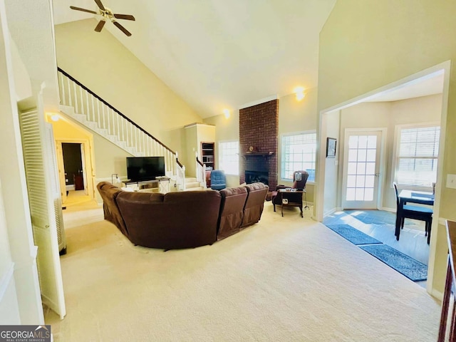 carpeted living room featuring a fireplace, plenty of natural light, and high vaulted ceiling