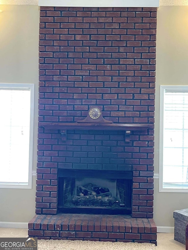 details with a brick fireplace and carpet flooring