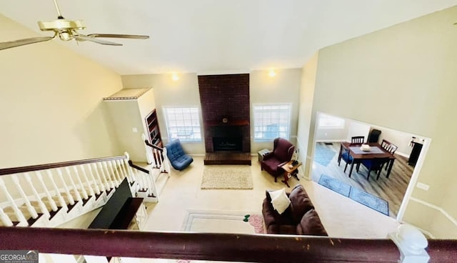 living room with a brick fireplace and ceiling fan