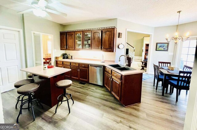 kitchen featuring sink, decorative light fixtures, light hardwood / wood-style flooring, and dishwasher