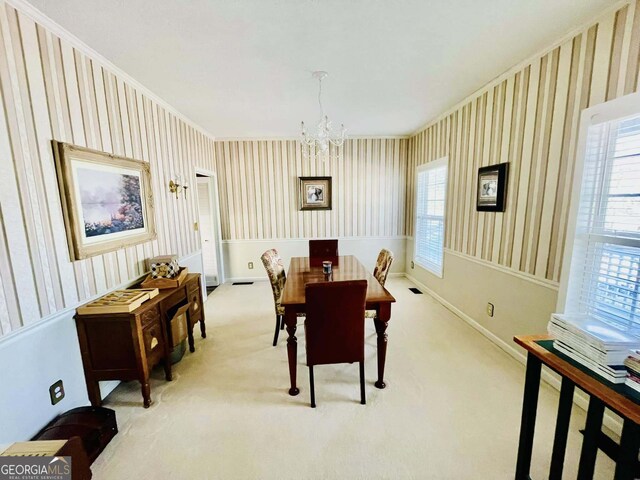 dining area with light colored carpet and a chandelier