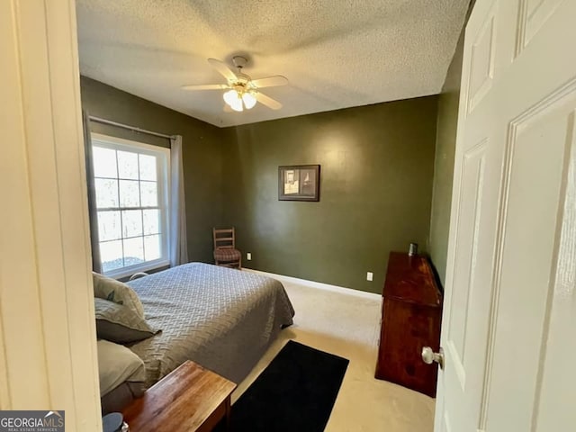 carpeted bedroom featuring ceiling fan and a textured ceiling