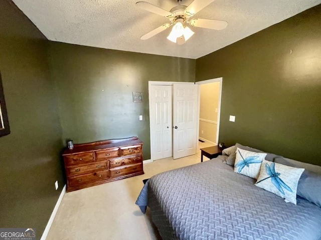 bedroom with ceiling fan, a closet, a textured ceiling, and carpet flooring