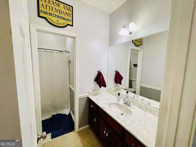 bathroom featuring a shower with curtain, vanity, and toilet