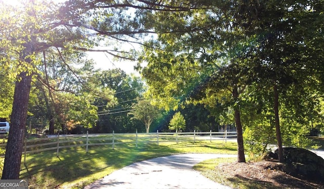 view of property's community with a rural view and a lawn