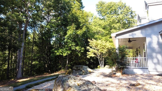 view of yard featuring ceiling fan and covered porch