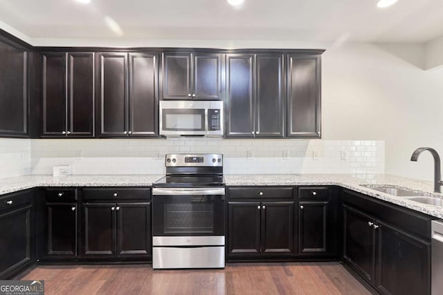 kitchen featuring backsplash, dark wood-type flooring, sink, and stainless steel appliances