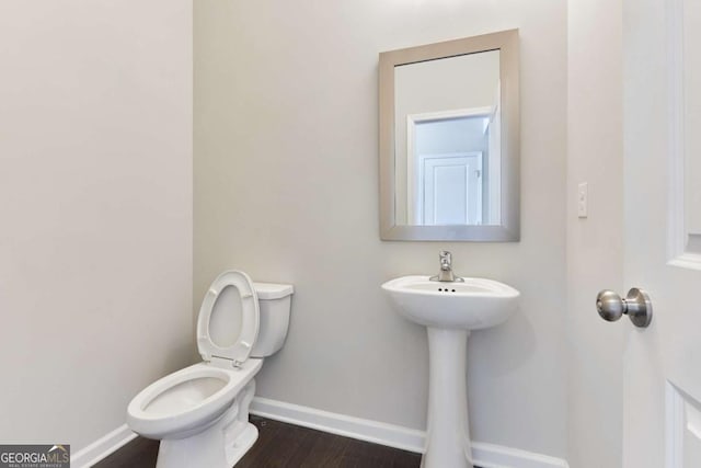 bathroom with sink, hardwood / wood-style floors, and toilet