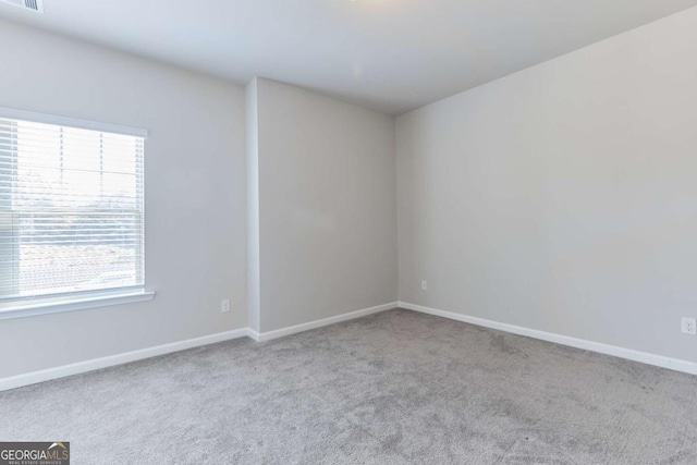 carpeted spare room featuring a wealth of natural light