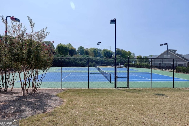 view of tennis court featuring a lawn