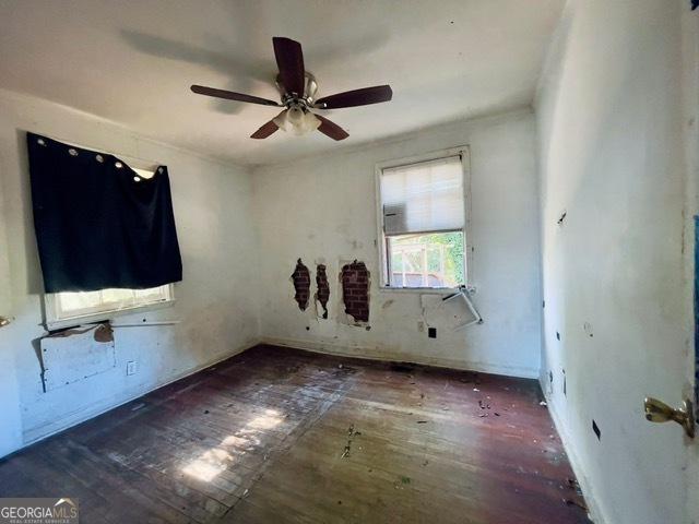 unfurnished room with dark wood-type flooring and ceiling fan