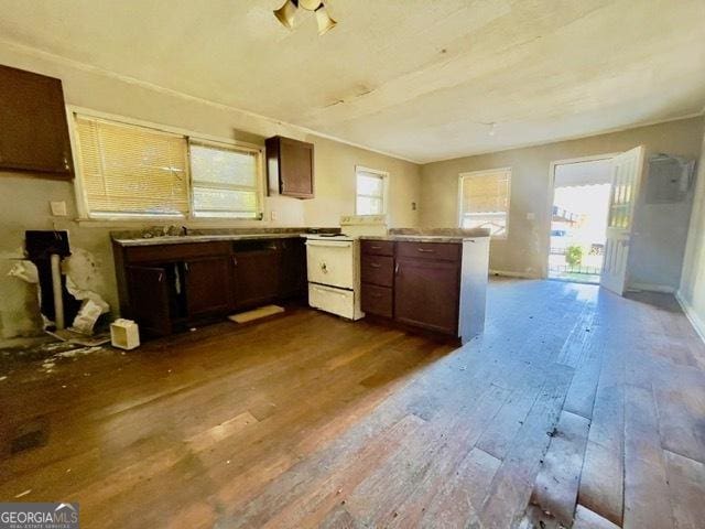 kitchen with dark brown cabinets, wood-type flooring, and kitchen peninsula