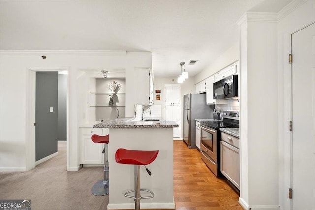 kitchen featuring appliances with stainless steel finishes, backsplash, light stone counters, a breakfast bar, and white cabinetry