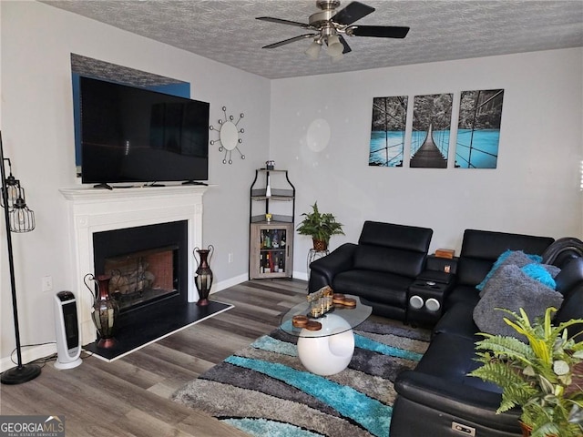 living room with a textured ceiling, hardwood / wood-style flooring, and ceiling fan