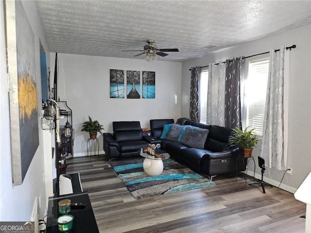 living room with ceiling fan, wood-type flooring, and a textured ceiling