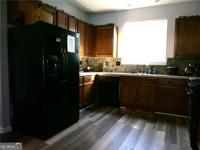 kitchen with dark hardwood / wood-style flooring, sink, tasteful backsplash, and black appliances