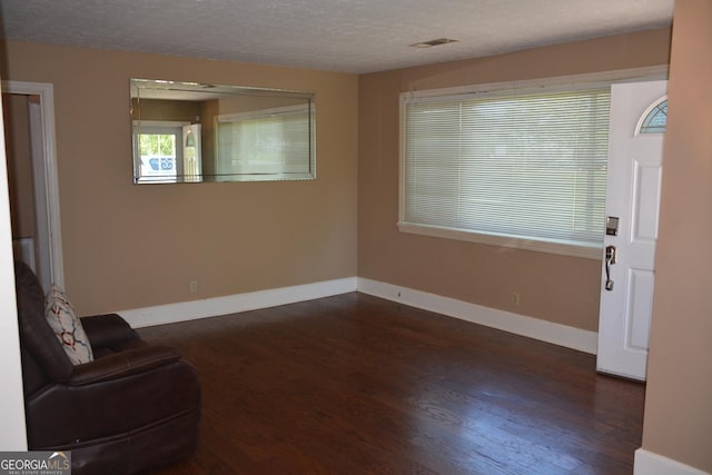 interior space with dark hardwood / wood-style flooring and a textured ceiling