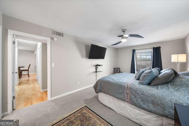 carpeted bedroom featuring a textured ceiling and ceiling fan