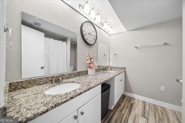 bathroom featuring vanity, wood-type flooring, and a textured ceiling