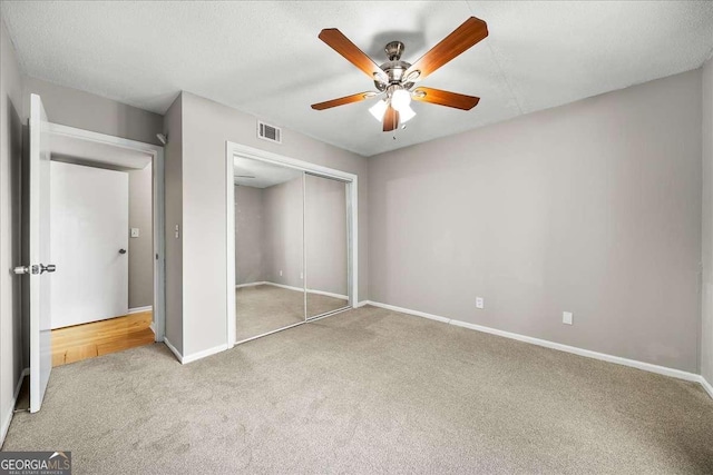 unfurnished bedroom with carpet, ceiling fan, and a closet