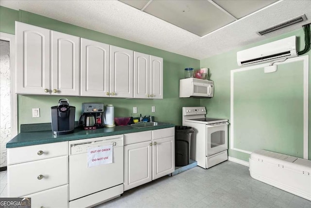 kitchen with white appliances, white cabinets, sink, a textured ceiling, and a wall mounted AC