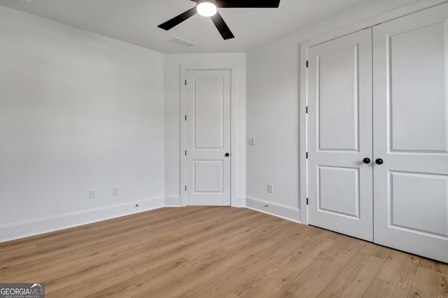 unfurnished bedroom featuring ceiling fan, a closet, and light hardwood / wood-style flooring