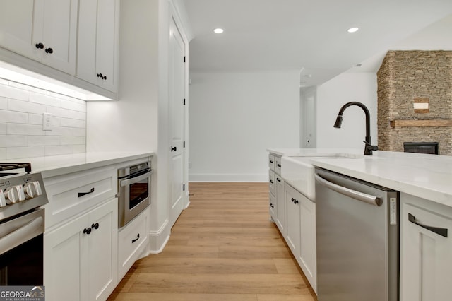 kitchen with white cabinetry, appliances with stainless steel finishes, and tasteful backsplash