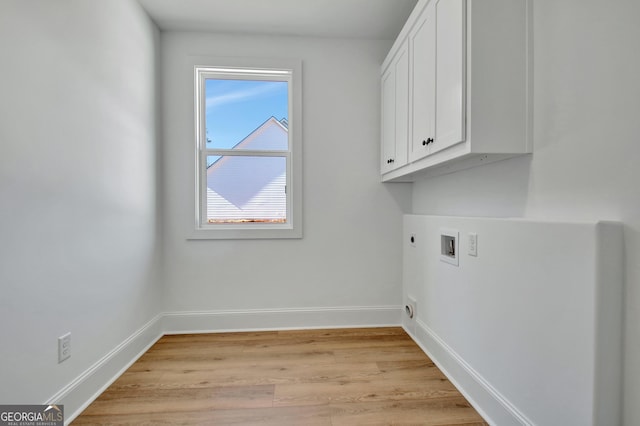 clothes washing area featuring hookup for a washing machine, cabinets, light hardwood / wood-style flooring, and hookup for an electric dryer