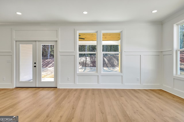 unfurnished room with light wood-type flooring and french doors