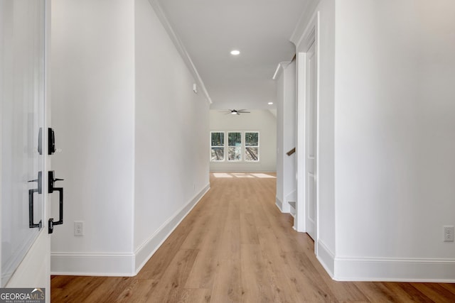 hall with crown molding and light hardwood / wood-style flooring