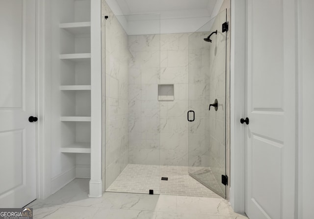 bathroom with built in shelves and a shower with door