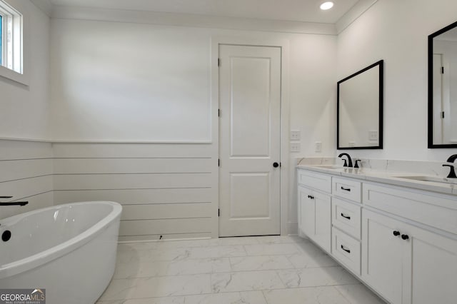 bathroom with a bathtub, vanity, and crown molding