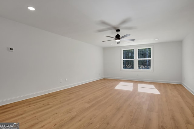 empty room with ceiling fan and light hardwood / wood-style floors