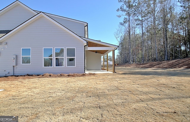 view of side of home with a yard and a patio