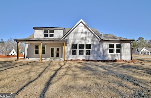 rear view of house with a patio area, french doors, and a lawn