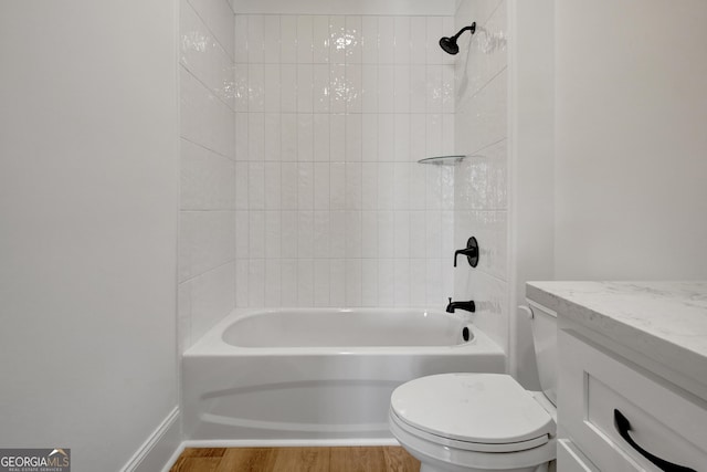 full bathroom featuring toilet, tiled shower / bath, wood-type flooring, and vanity