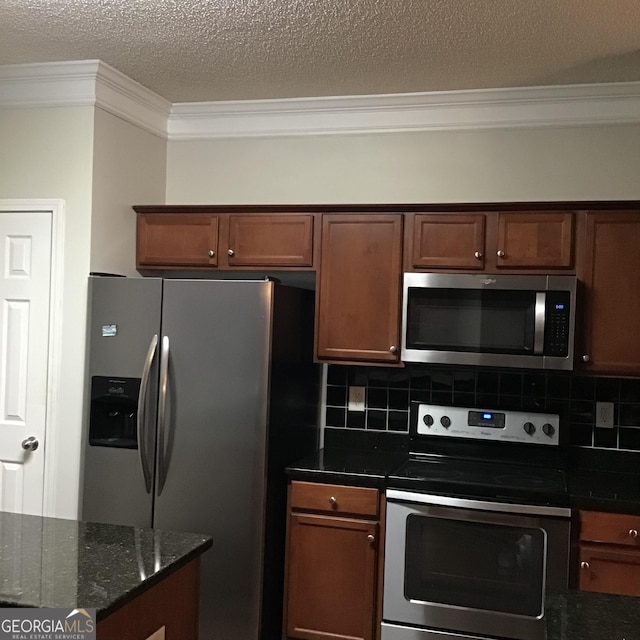 kitchen with appliances with stainless steel finishes, backsplash, dark stone countertops, a textured ceiling, and ornamental molding