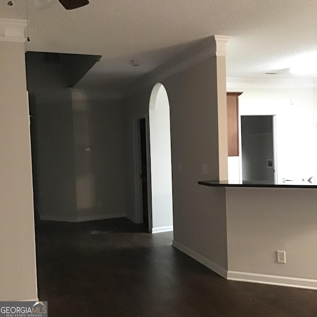 empty room featuring a textured ceiling, ceiling fan, and crown molding