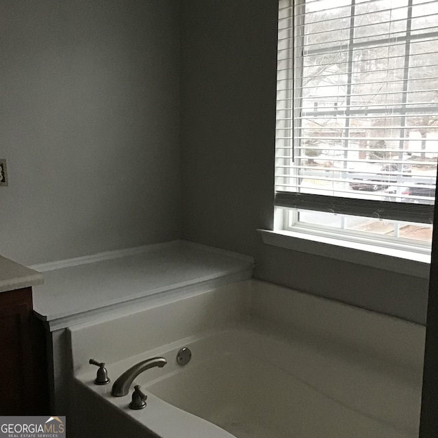 bathroom with vanity and a tub