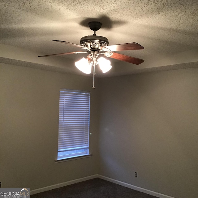 empty room with ceiling fan, carpet floors, and a textured ceiling