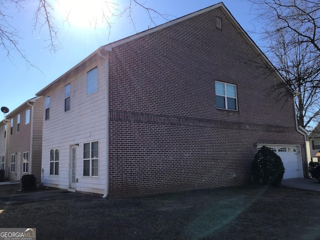 view of property exterior featuring a garage and cooling unit