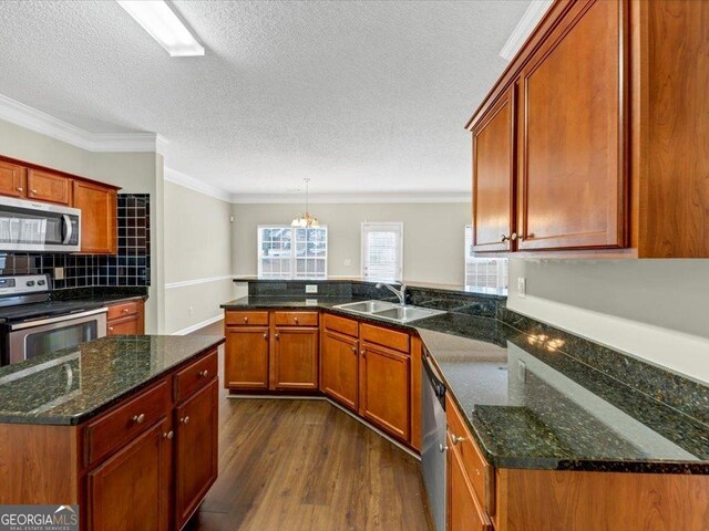 kitchen featuring a textured ceiling, ceiling fan, crown molding, and sink