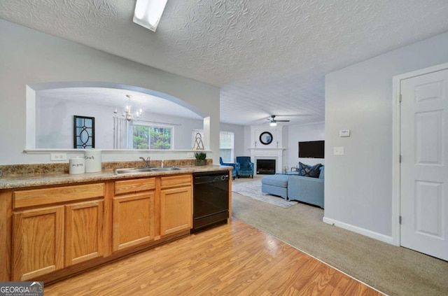 kitchen featuring dishwasher, sink, light hardwood / wood-style flooring, a textured ceiling, and ceiling fan with notable chandelier