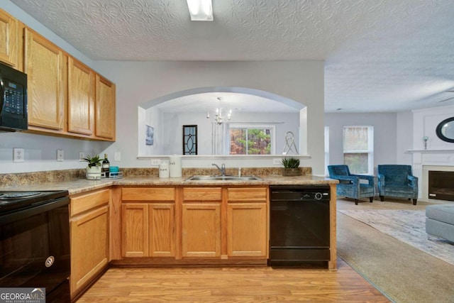 kitchen with an inviting chandelier, black appliances, sink, light hardwood / wood-style flooring, and a textured ceiling