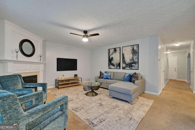 living room with ceiling fan, a textured ceiling, and light carpet