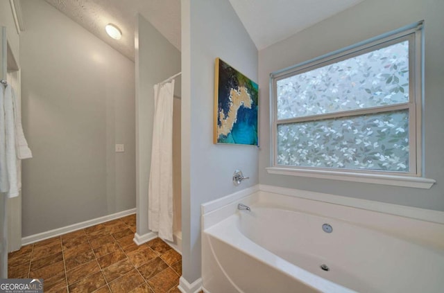 bathroom featuring a textured ceiling, independent shower and bath, and vaulted ceiling