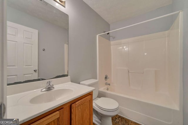 full bathroom with tile patterned floors, a textured ceiling, toilet, shower / washtub combination, and vanity